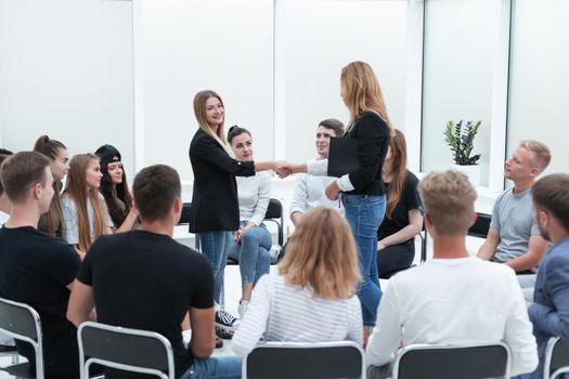 young people shaking hands in a circle of like-minded people