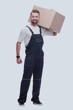 in full growth. a man in overalls with a box on his shoulder