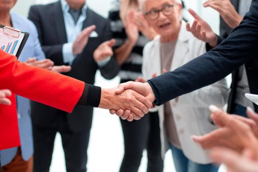 colleagues handshaking after meeting in office
