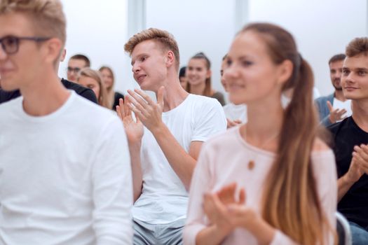 variety of young people applaud in a group meeting