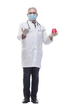 in full growth. doctor in a protective mask with a laboratory bottle