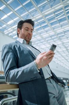 businessman with smartphone standing in the airport building