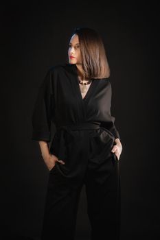 Studio shot of brunette woman 30s wearing black silk pajamas