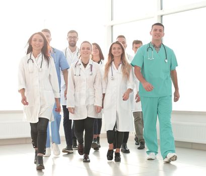 group of confident doctors striding in the hospital corridor