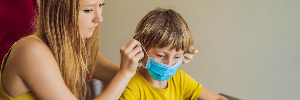 Boy studying online at home using a tablet. Mom helps him learn. Mom and son in medical masks to protect against coronovirus. Studying during quarantine. Global pandemic covid19 virus BANNER, LONG