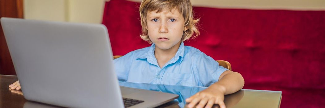 Boy studying online at home using laptop. Studying during quarantine. Global pandemic covid19 virus BANNER, LONG FORMAT