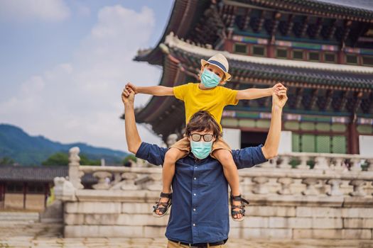Dad and son tourists in medical mask in Seoul, South Korea. Travel to Korea concept. Traveling with children concept Tourists fear the 2019-ncov virus. Medical masked tourists