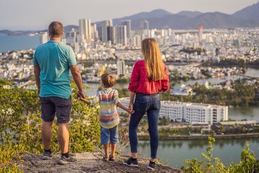 Happy family tourists on the background of Nha Trang city. Travel to Vietnam with kids Concept