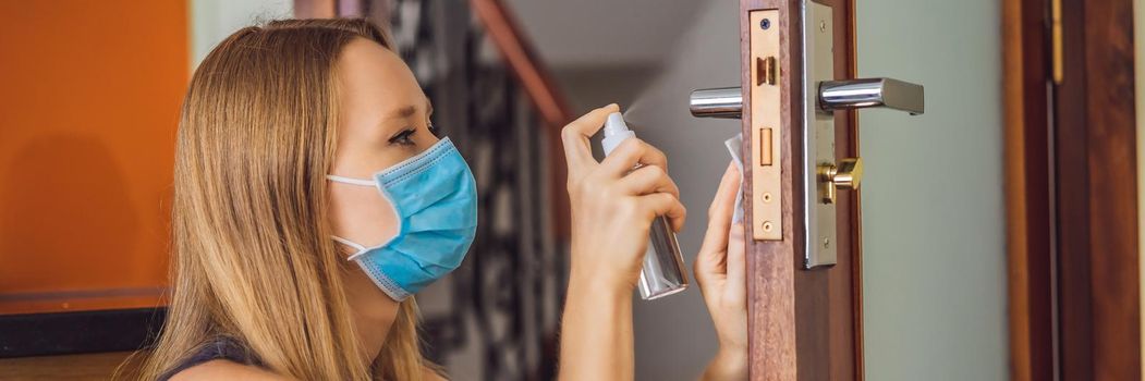 Woman hand is applying sanitizer on the door handle. Cleaning door handle with alcohol spray for Covid-19 Coronavirus prevention. disinfecting the door handle by spraying alcohol BANNER, LONG FORMAT