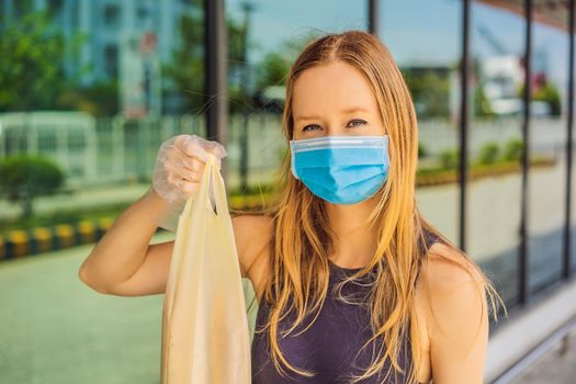 Woman hands in medical protective gloves hold package with purchases