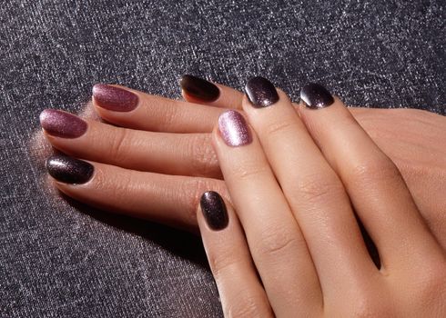 Manicured nails with shiny nail polish. Manicure with bright nailpolish. Fashion art manicure with shiny gel lacquer