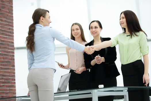 agent and customer shaking hands after signing contract documents