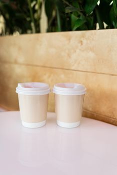 Two paper coffee cups in a cafe, coffee to go concept. Walks in the open air.