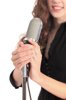 Closeup portrait of a pretty young female star performer holding old fashioned microphone