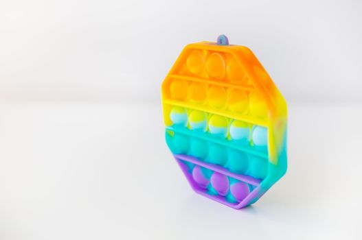 The most fashionable sensory toy. New popular colorful hexagon shaped pop it anti stress toy. Fidget toy Rainbow Pop, place for text. Side view.