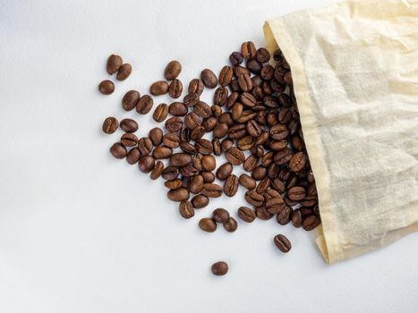 Coffee beans roasted in a jute bag on a white background