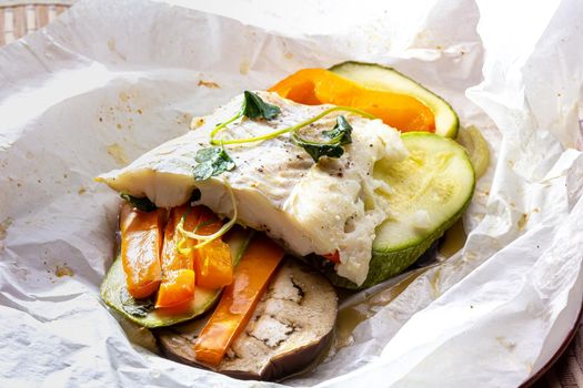 White fish fillet with vegetables in rustic style. Healthy eating: cooked fish fillet with vegetables garnish. Diet food with white fish and vegetables. Steam vegetables with roasted zander fillet