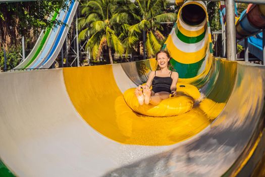 Happy woman going down a water slide