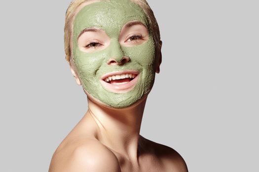 Beautiful Woman Applying Green Facial Mask. Beauty Treatments. Close-up Portrait of Spa Girl Apply Clay Facial mask