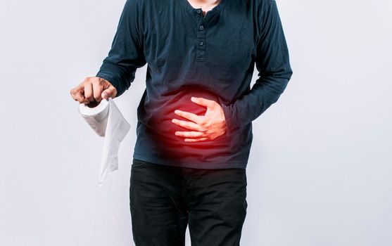 Person with toilet paper with stomach problems on isolated background, Concept of a person with digestive and diarrhea problems, Man with stomach problems holding toilet paper