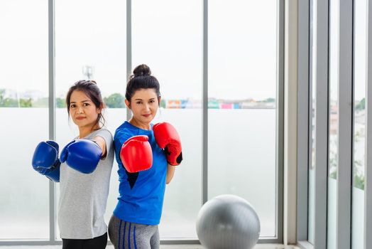 adult and young woman smiling sports fitness boxer wearing gloves practicing kick on boxing