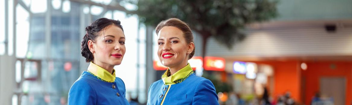 Two female flight attendants standing in airport terminal