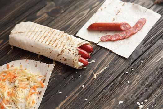 sausages in pita bread on wooden background