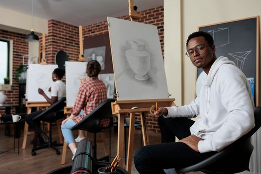 Portrait of painter student attending art class working at creative artwork