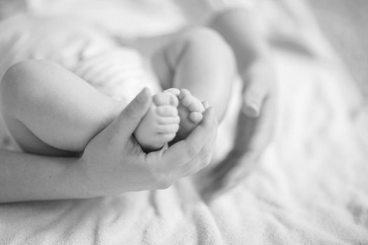 concept of tenderness:a mother holding foot of newborn baby