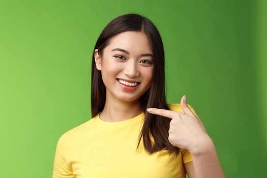 Close-up joyful proud asian assertive girl introduce herself, pointing own face smiling joyfully, boastful telling own achievement, bragging accomplishment, assure can deal with work