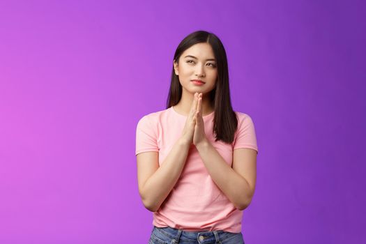 Cunning smart good-looking asian woman rubbing hands together scheming, squinting suspicious focused have evil plan, look upper left corner, sly idea, stand purple background