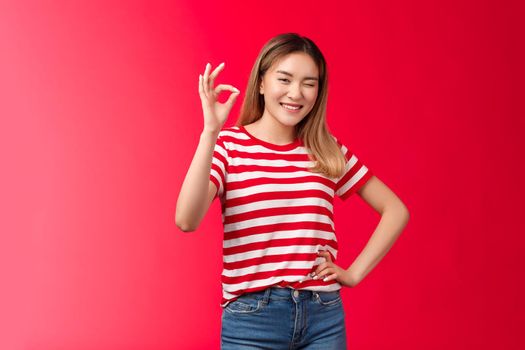 Good job mate. Proud happy female coworker approve your effort show okay gesture winking joyfully congratulate friend excellent plan, say well done make ok good approval gesture, red background