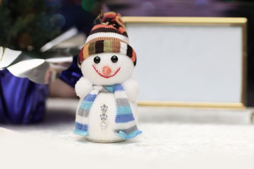 fun toy snowman in knit hat and scarf and blank Christmas backgr