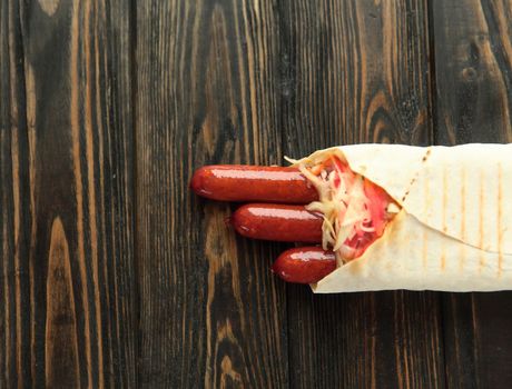 spicy sausages in pita bread on wooden background.photo with copy space