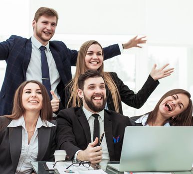concept of business success - cheering business team in the workplace in the office