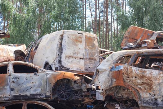 car graveyard. Burnt and blown up car. Cars damaged after shelling from russian invasion. War between Russia and Ukraine. Terror attack bomb shell. Disaster area irpin bucha