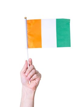 A hand holds a flag The flag of the Ivory Coast country on a white isolated background.