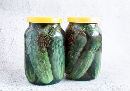 Pickled cucumbers in glass jars with lids
