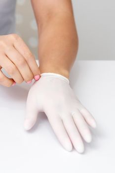 Female hands putting on protective gloves