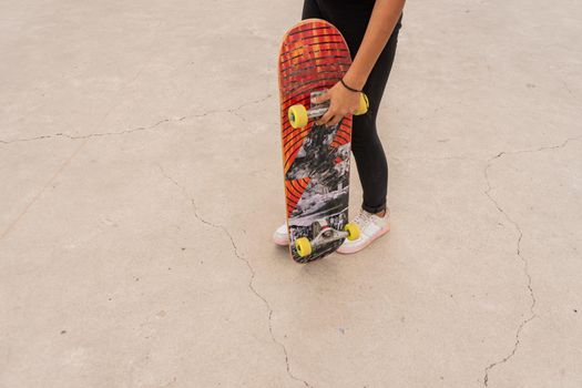 Unrecognizable latina teenage female skater holding a board about to do stunts in Nicaragua