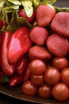Close up of various red veggies and fruit.