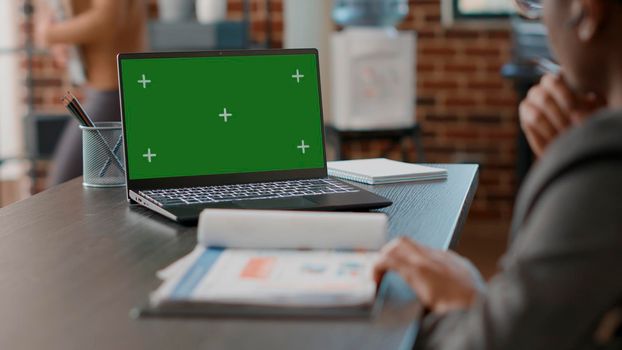Man using greenscreen on laptop and taking notes