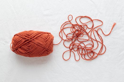 A ball of cotton yarn ocher color on a white table