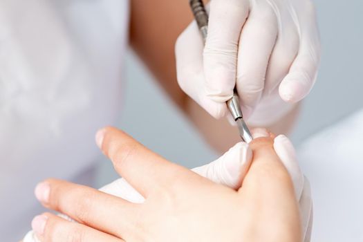Woman receiving nail care procedure