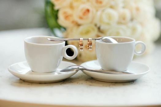 Bride and groom's Coffee time, coffee break.Cups and rings on teaspoon