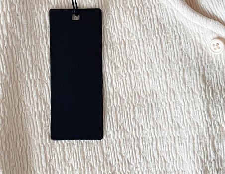 Luxury black fashion label tag, sale price card on fabric background, shopping and retail