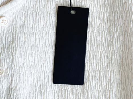Luxury black fashion label tag, sale price card on fabric background, shopping and retail