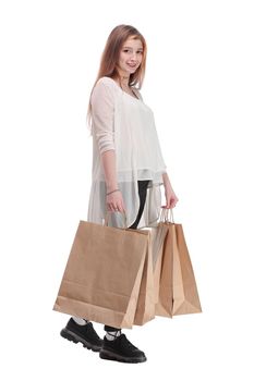 Studio photo of pretty woman walking, carrying paper shopping bags