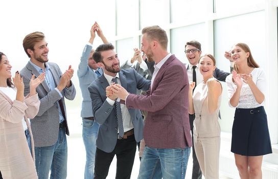 happy young business man accepting congratulations from his colleagues.