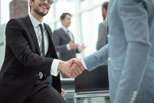 happy young businessman shaking hands with his business partner
